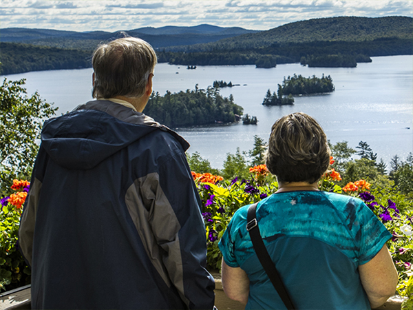 Una pareja disfruta de las vistas del lago Blue Mountain desde la terraza del Lake View Cafe en el Adirondack Experience.