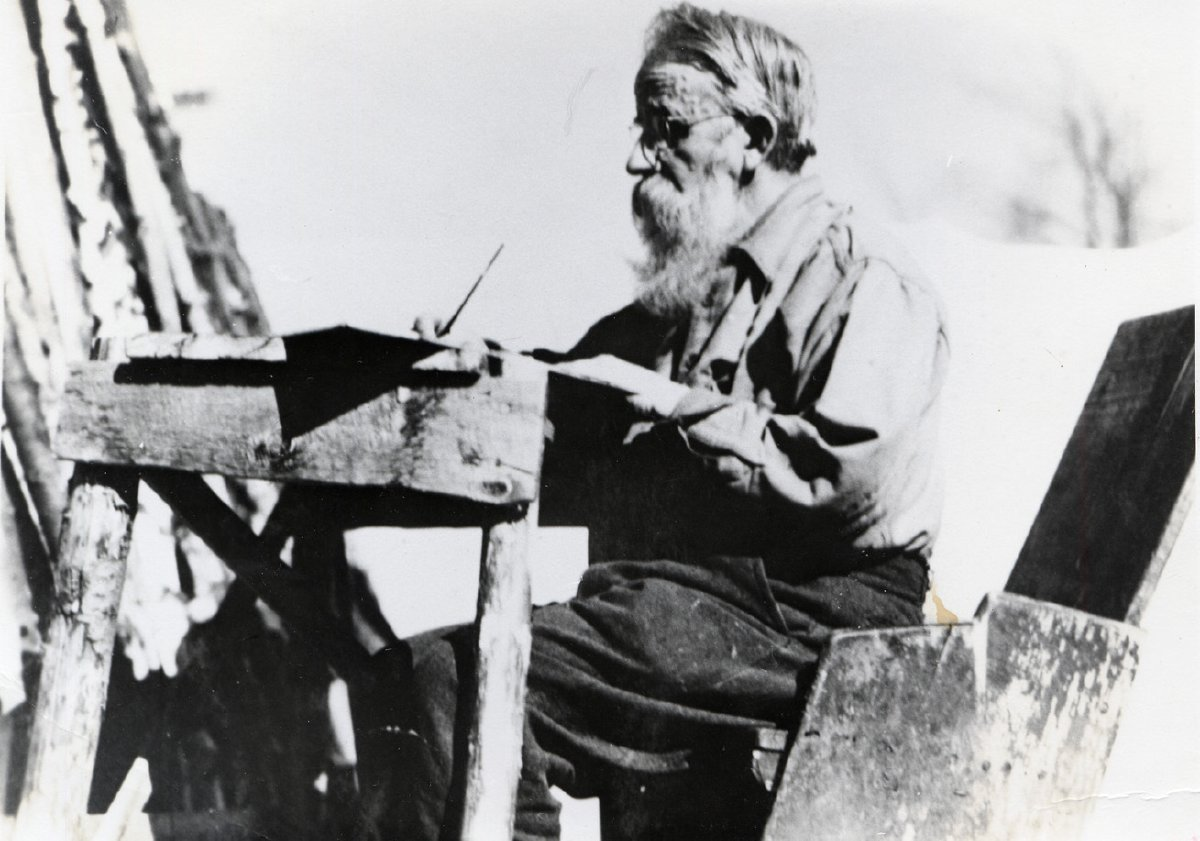 Noah John Rondeau writing at his outside desk, c. 1940 (P029046)