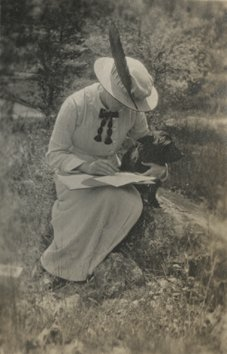 Una mujer escribiendo con su cachorro. c. 1900-1914. (P025434)