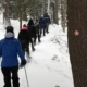 Un grupo de miembros de la ADKX en una excursión con raquetas de nieve en Minnow Pond.