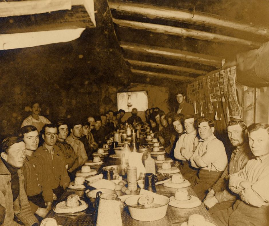 A group of people are sitting around a table in a cabin.