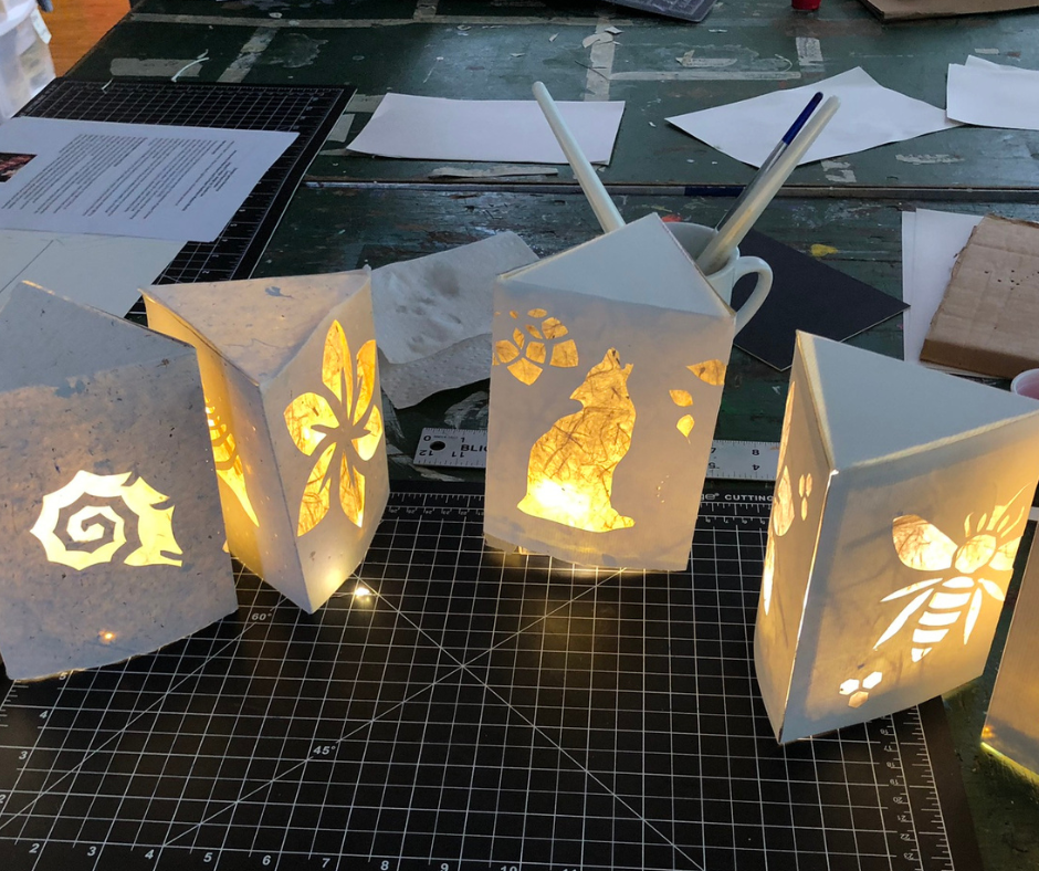 A table with four white boxes, each containing a lighted design.