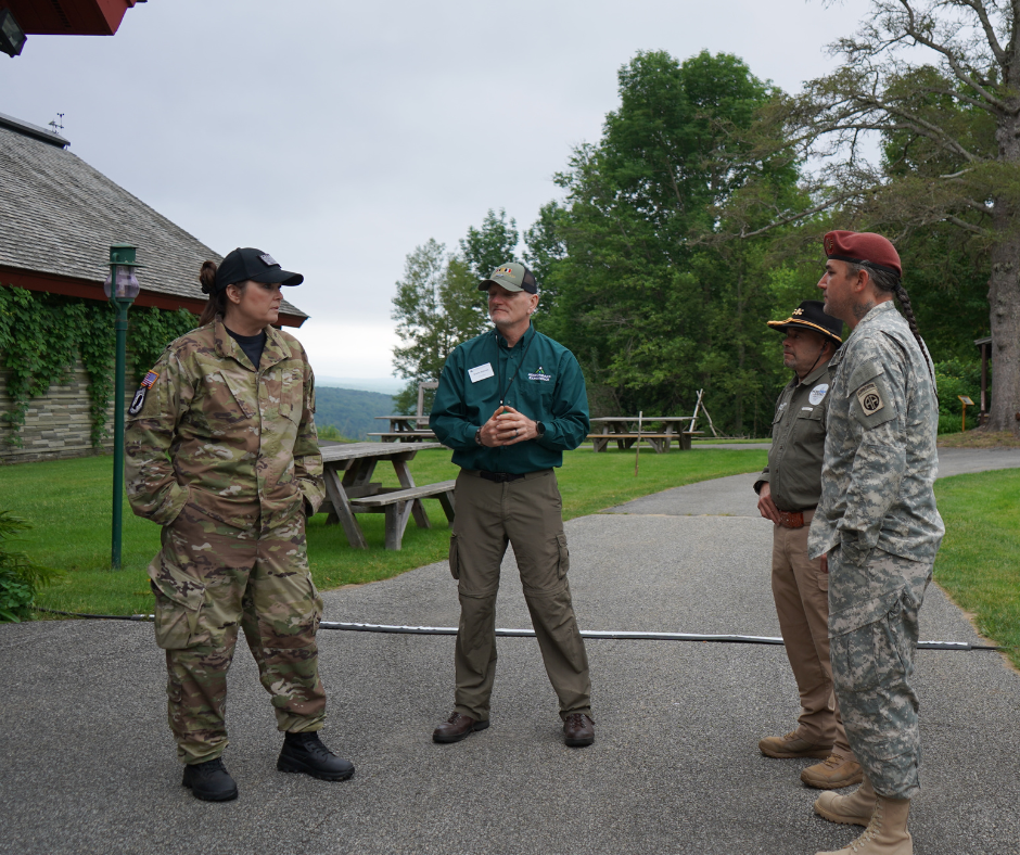Cuatro personas con uniforme militar están juntas en una acera.